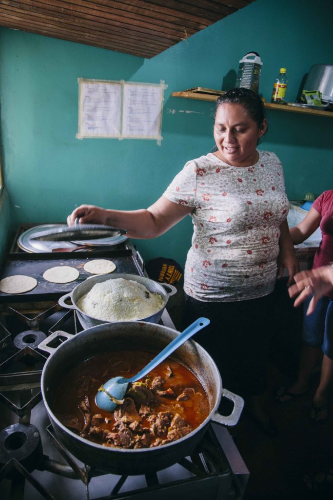 A woman prepares a meal for children