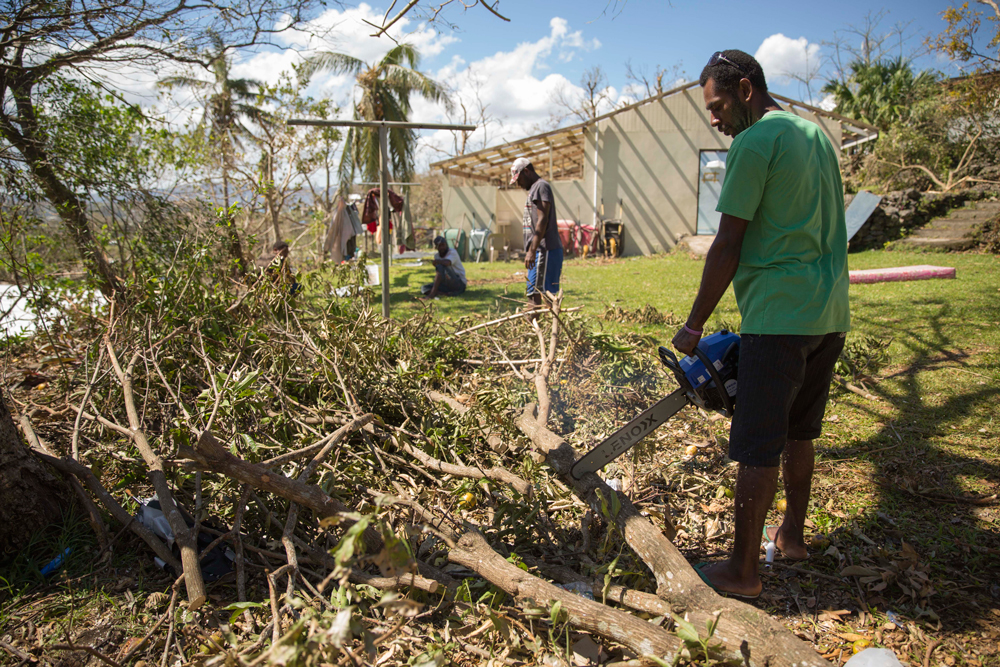 A Vanuatuan man cleans debris after Cyclone Pam caused major destruction on the island nation.