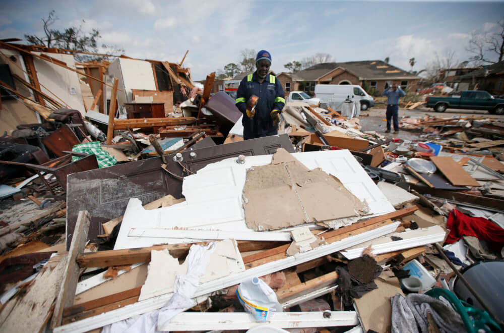 Willie Anderson tries to salvage possessions from his daughter's destroyed home, in the aftermath of Tuesday's tornado that tore through the New Orleans East section of New Orleans, Wednesday, Feb. 8, 2017. (AP Photo/Gerald Herbert)