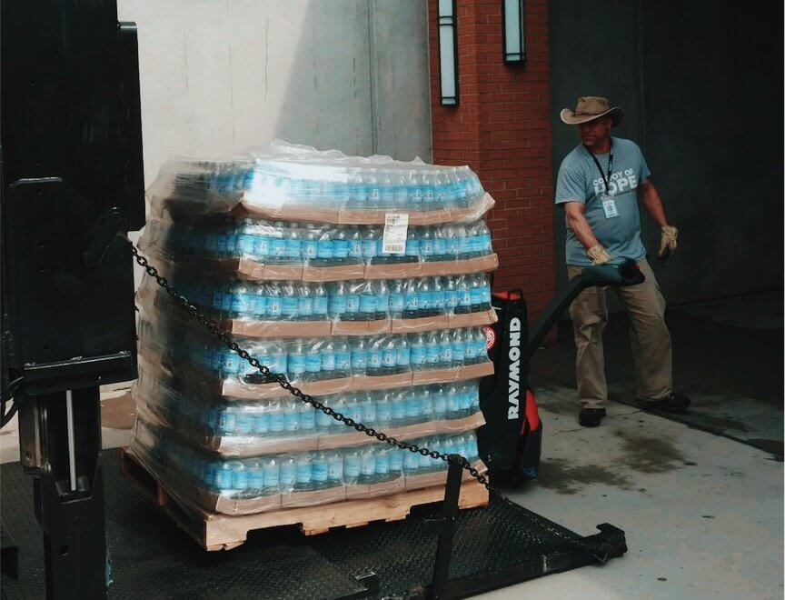A Convoy of Hope team member loads water onto a truck
