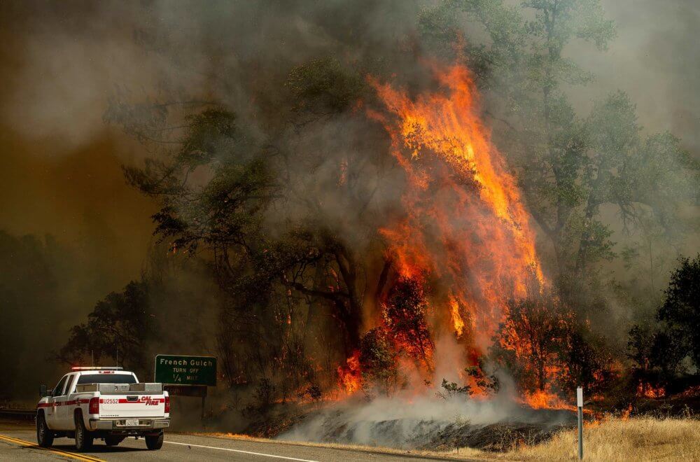 Flames from the Carr Fire swirl around a Cal Fire truck in Whiskeytown, Calif., on Friday, July 27, 2018