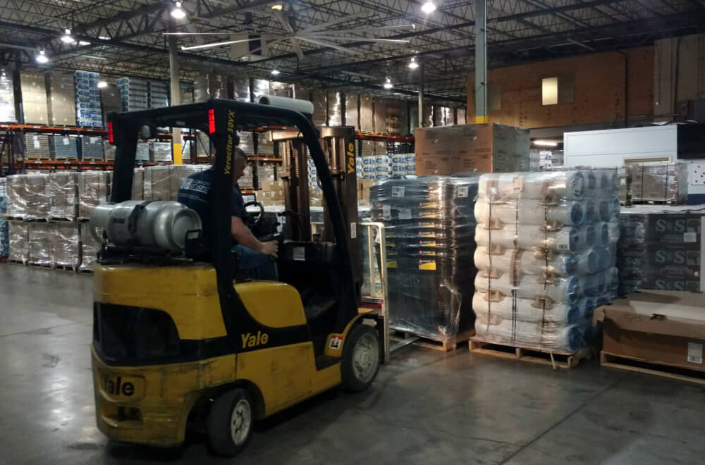A forklift moves relief supplies in a warehouse