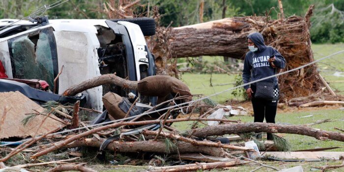 An area resident looks at the remnants of cars, houses and mobile homes in this Bassfield, Miss., neighborhood, Monday, April 13, 2020. The community was one of many in Mississippi swept by a series of tornadoes, Sunday afternoon and evening. (AP Photo/Rogelio V. Solis)