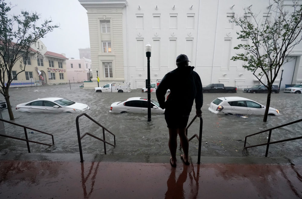 A person looks at a flooded street from Hurricane Sally