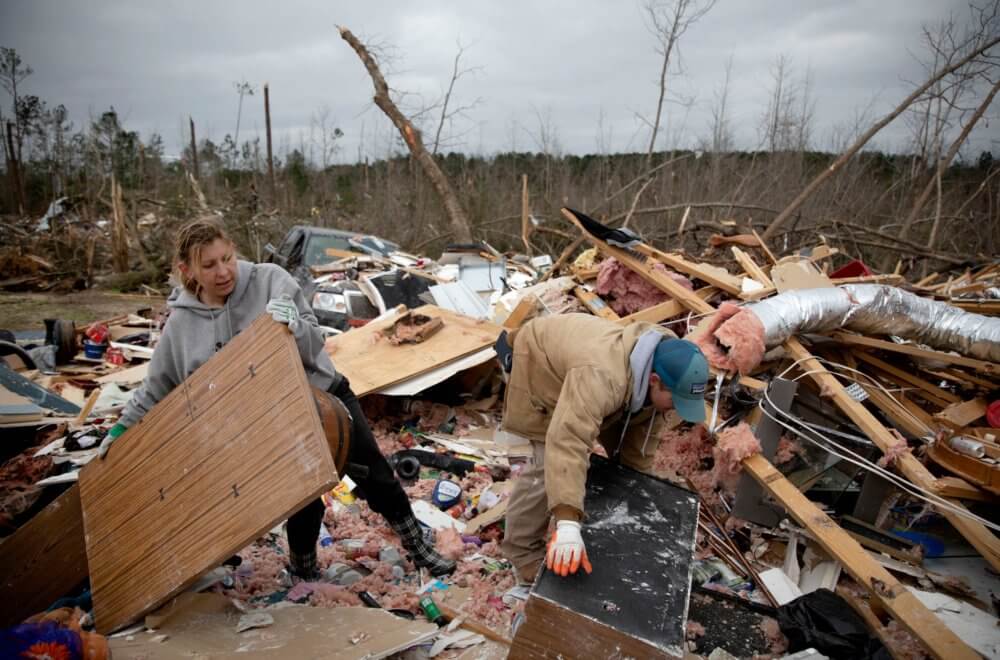Ashley Griggs, left, helps Joey Roush sift through what is left of his mother's home after it was destroyed by a tornado in Beauregard, Ala., Monday, March 4, 2019. (AP Photo/David Goldman)