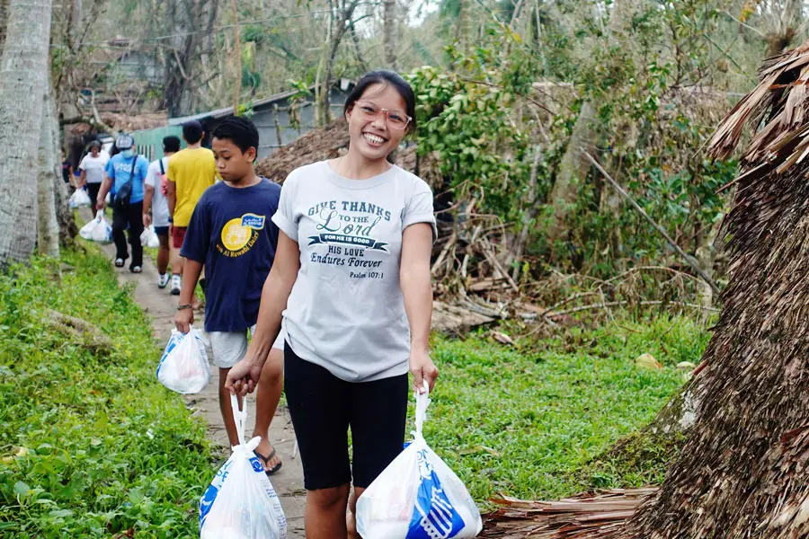 Woman walks with Convoy of Hope supply bags