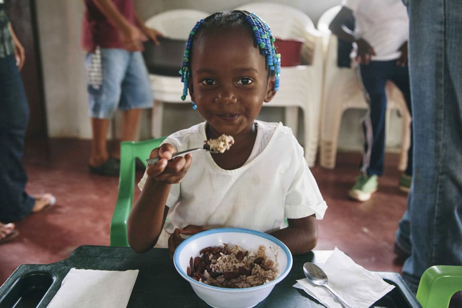 Child in El Salvador Holds Plate of Hot Food