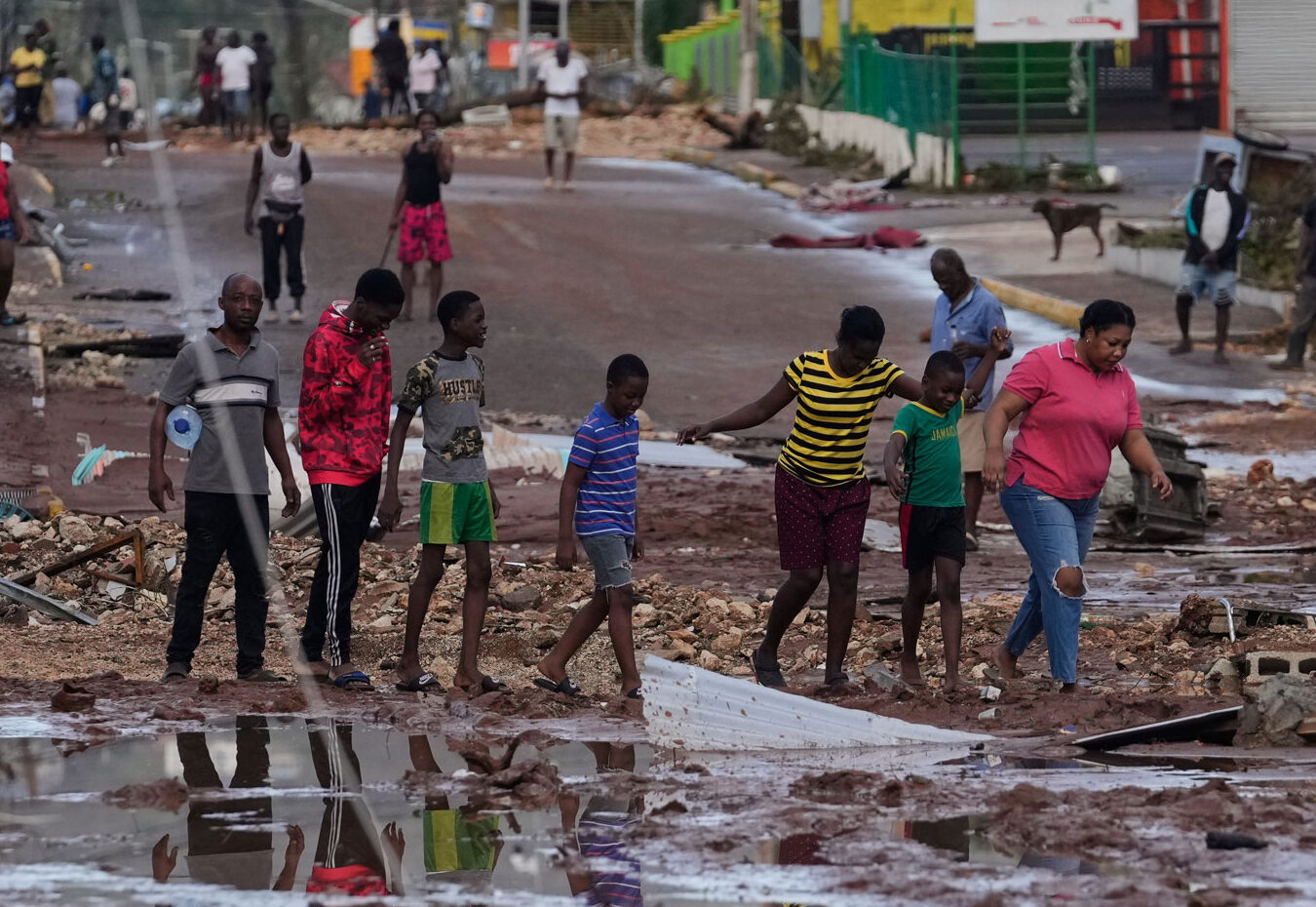 People walk through Santa Cruz, Jamaica, Wednesday, Oct. 29, 2025, after Hurricane Melissa passed. (AP Photo/Matias Delacroix)