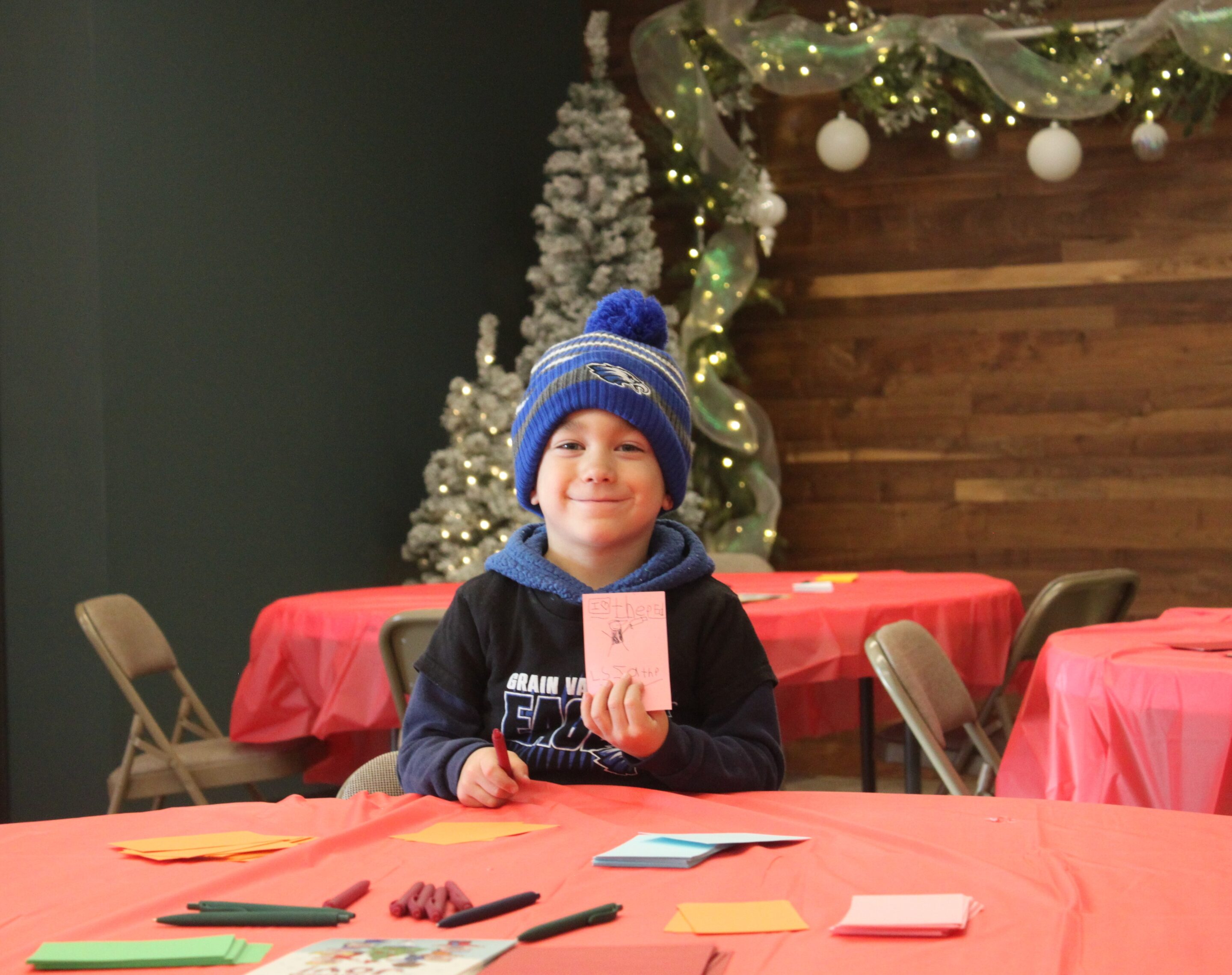 A young child shows off the card he made.