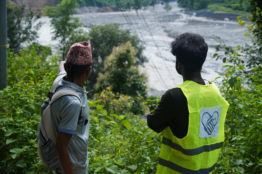 A Convoy of Hope teammate surveys the extent of the damage with a flood survivor.